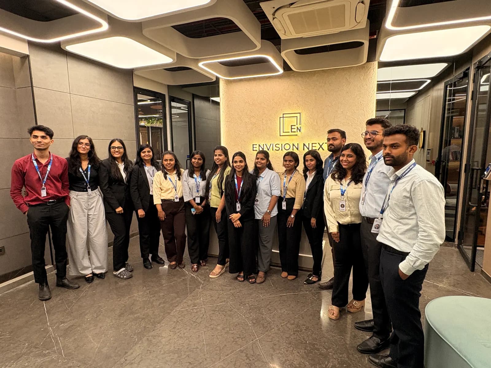 Colleagues gathered under the illuminated brand wall