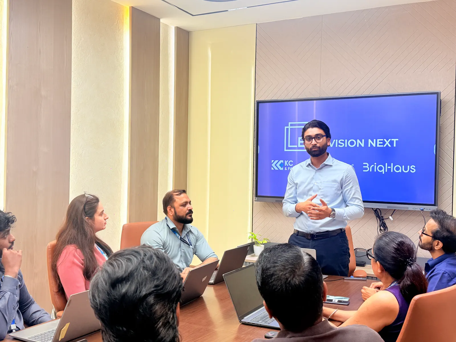 A colleague presenting to the team around the conference table